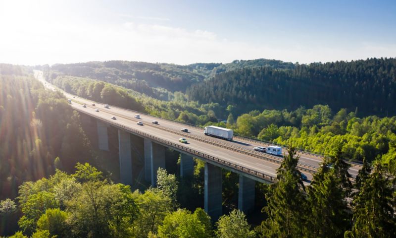 Cars and trucks drive over a bridge