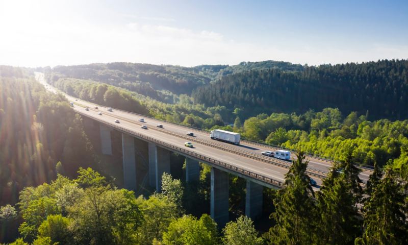 Des voitures et un camion roulent sur un pont