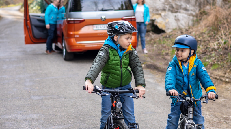 Flurin e Gian vanno dietro il Multivan con le loro biciclette.