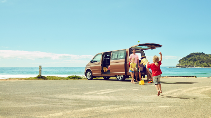 Family by the beach unloading orange Multivan