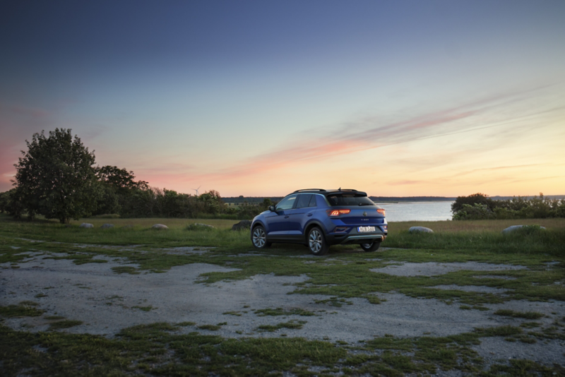 En blå T-Roc parkerad, havet i bakgrunden 