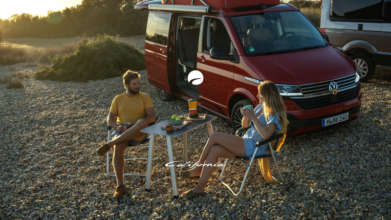Ett par sitter och fikar utanför sin VW California husbil.