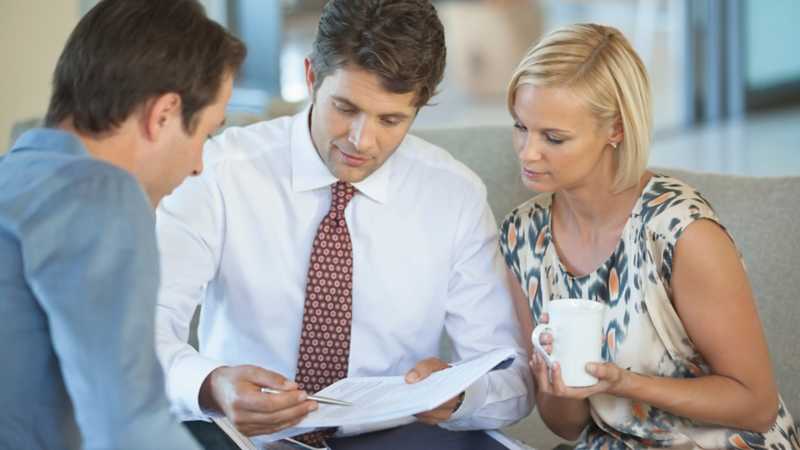 Trois employés sont assis et regardent un document. 