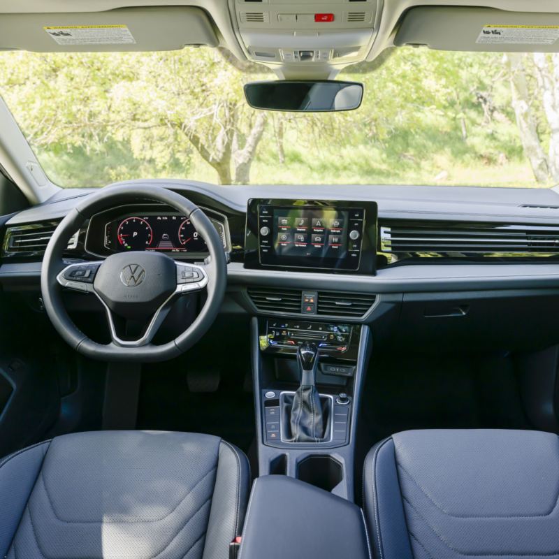 Vue intérieure de la Volkswagen Jetta 2025 mettant en valeur son nouveau design intérieur avec un focus sur le tableau de bord et le volant.