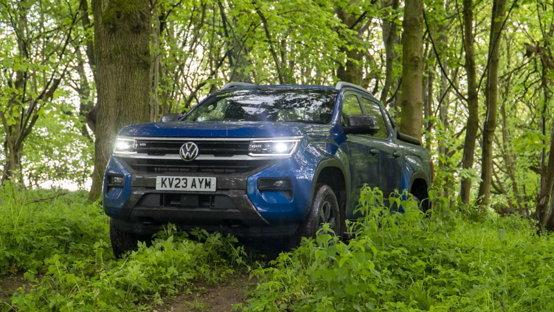 A blue VW Amarok driving down a countryside road. 