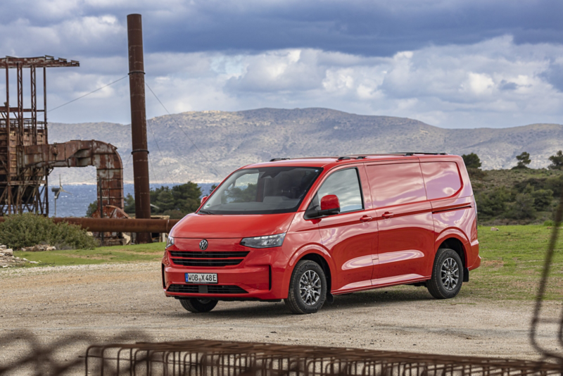Röd Volkswagen Transporter parkerad i industriell miljö