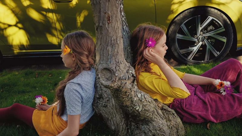 Two girls sitting under a tree