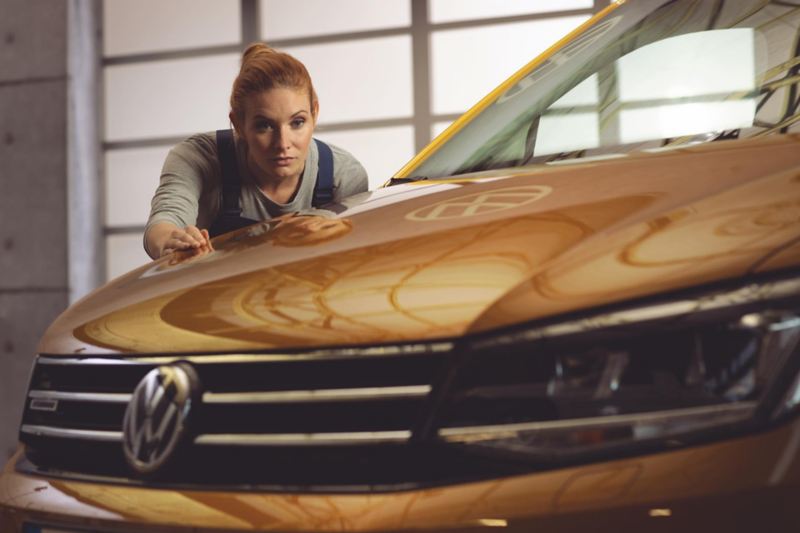 Une technicienne Volkswagen vérifie la réparation carrosserie d'une Volkswagen Véhicules Utilitaires