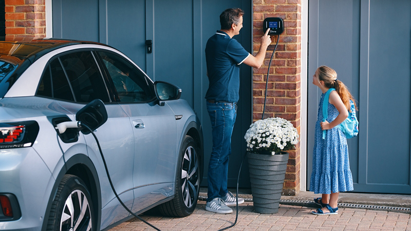Man and girl using Ohme charging station