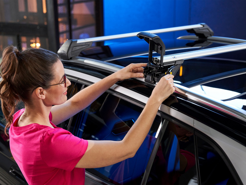 Woman installing roof racks onto VW car