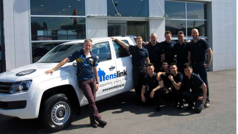 Menslink team stood outside ute