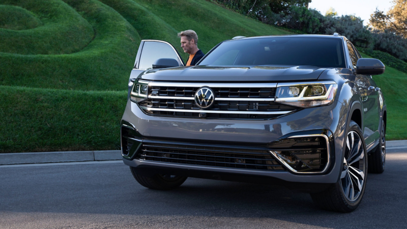 Homme se tenant à côté de l'Atlas Cross Sport, lien vers owners.vwmodels.ca