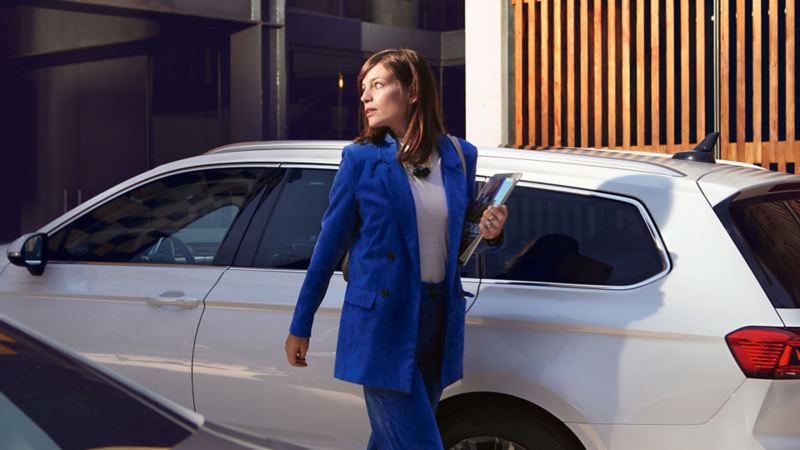 VW Passat GTE, VW Passat GTE Variant, vue arrière sur une place de stationnement, famille souriante au premier plan