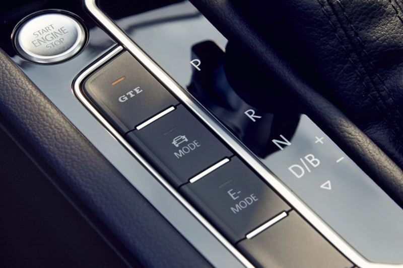 VW Passat GTE: Touches à gauche à côté du levier de vitesses, LED de la touche GTE allumée, bouton start-stop