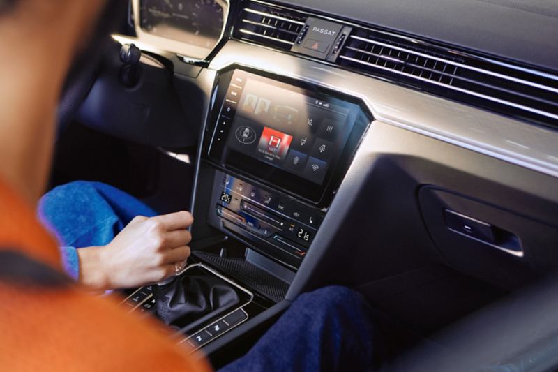 Console centrale de la VW Passat GTE avec système de navigation «Discover Pro», écran avec boussole, haut-parleurs, affichage Wi-Fi, Bluetooth, flux d’énergie et radio.