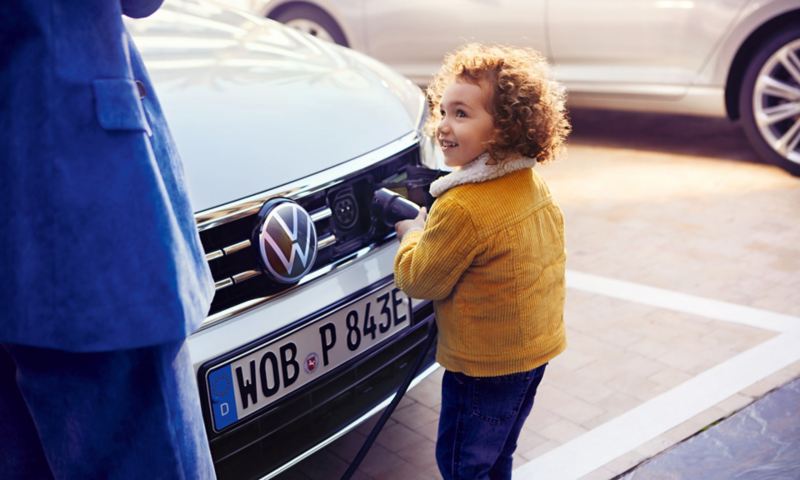 VW Passat GTE front, charging process, child pulls charging nozzle out of car