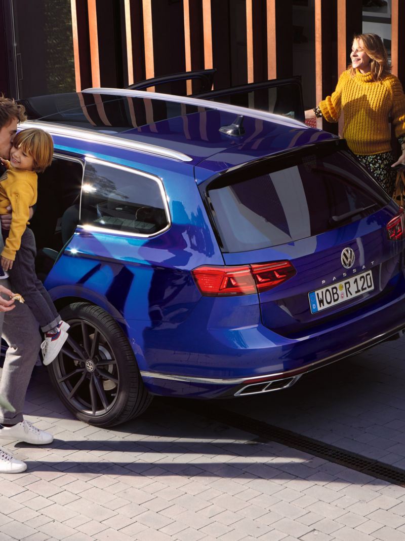 En familie står ved siden av VW Volkswagen Passat Stasjonsvogn