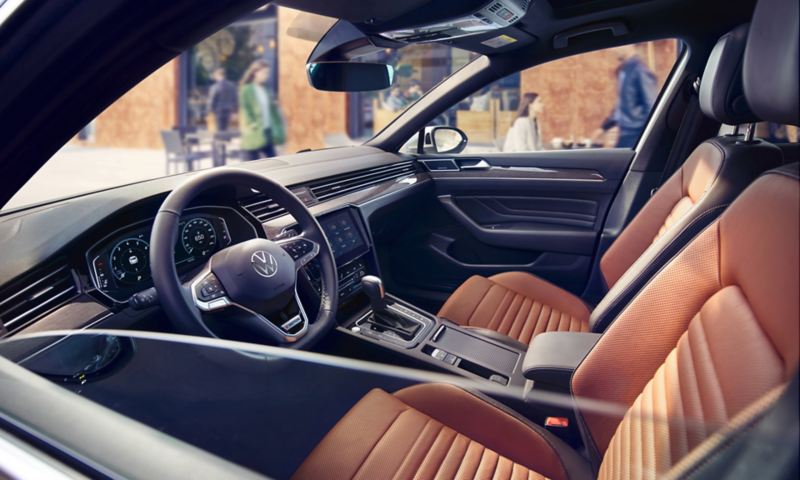 View through open driver’s window into the cockpit of the VW Passat Estate with optional leather multifunction steering wheel and optional leather seats.