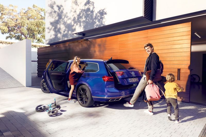 Volkswagen Passat Alltrack, “Easy Open”, vista posteriore di tre quarti, un uomo apre il portellone del bagagliaio con un movimento del piede (calcio) sotto il posteriore