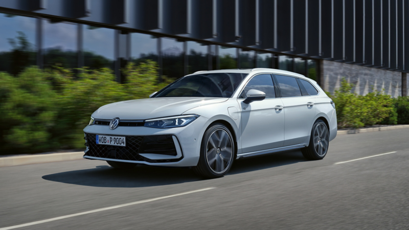 Une VW Passat blanche roule sur une route urbaine.