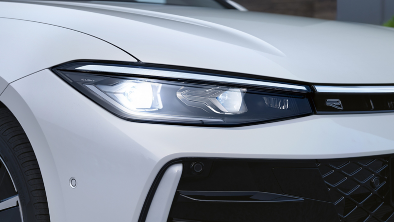 Vue détaillée de la signature lumineuse avant d’une VW Passat R-Line blanche.