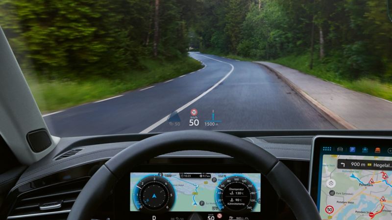 Vue de l’intérieur d’une VW Passat avec zoom sur le côté conducteur avec un grand écran couleur et l’affichage tête haute.