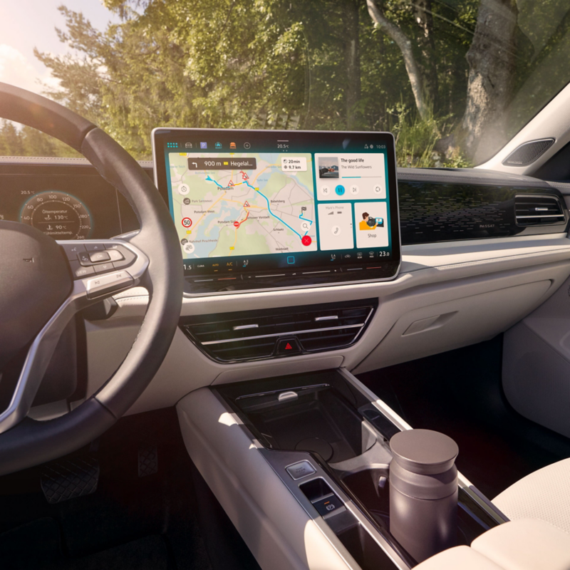 Two women in the interior of the car interacting with the display of the VW Passat.