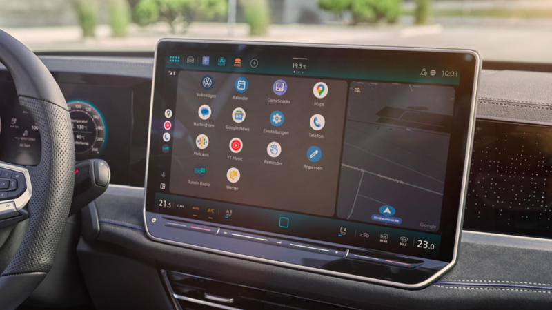 Detailansicht auf das Cockpit des VW Passast. Eine Person auf dem Fahrersitz hält ein Smartphone in der Hand.