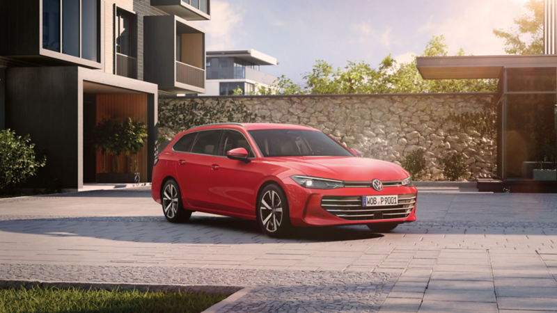 Une Passat rouge stationnée en diagonale dans la cour d'un complexe résidentiel moderne.