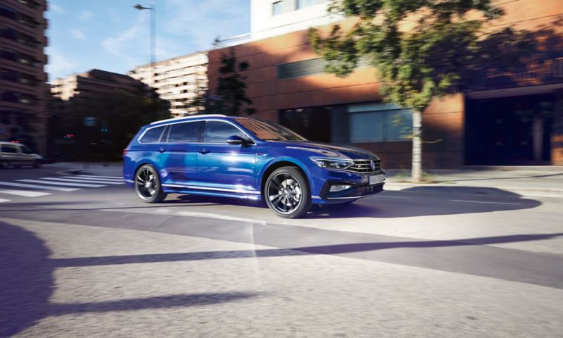 VW Passat Variant R-Line in Blau bewegt sich dynamisch im Straßenverkehr.