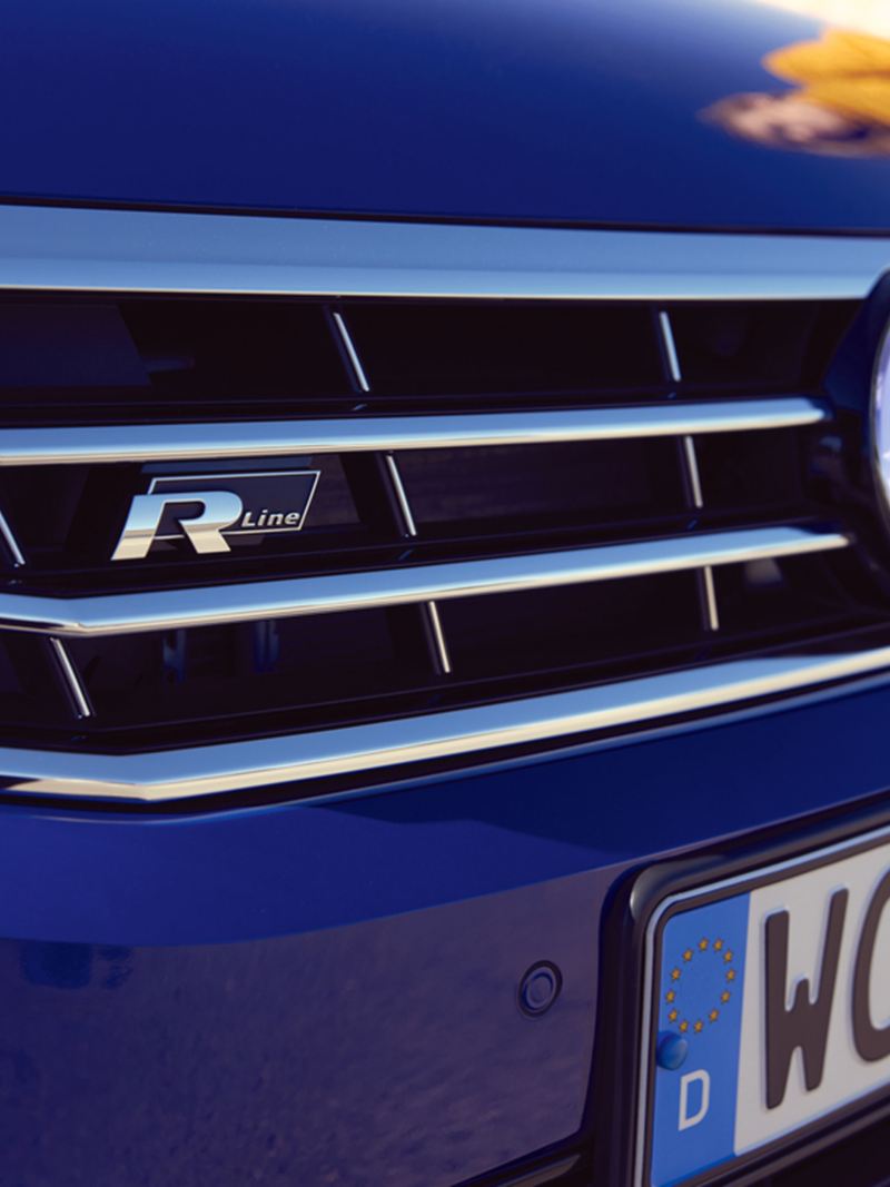 Nærbillede af kølergrillen med R-Line-logo på en blå VW Passat Variant.