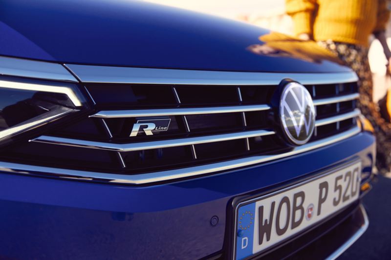 Detailed view of the radiator grille with R-Line logo of the VW Passat Estate in blue.