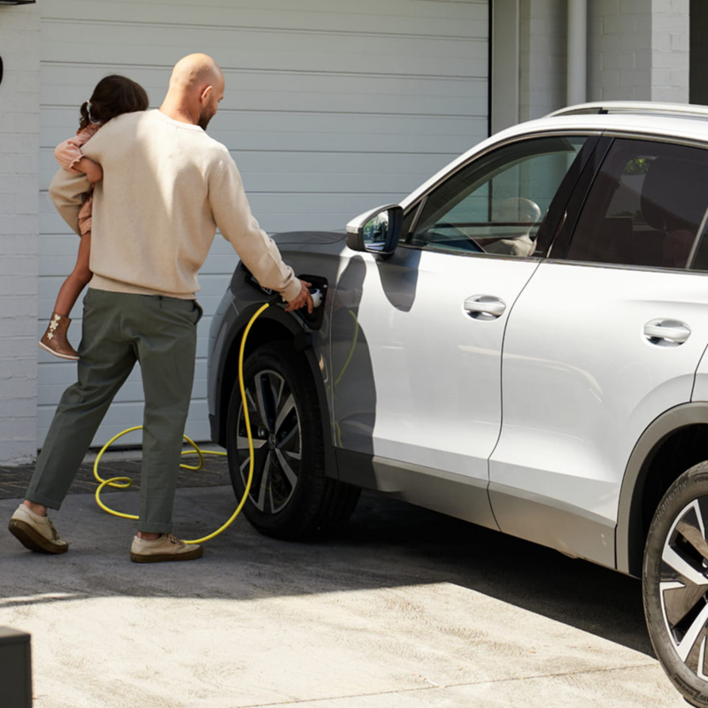 Plugging in the cable to charge their Tiguan eHybrid