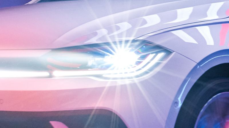 Close-up of the front of a white VW Polo GTI with LED matrix headlights switched on