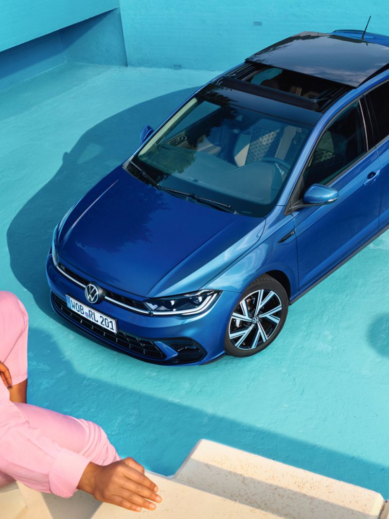 En blå VW Polo holder parkeret i en tom pool set oppefra