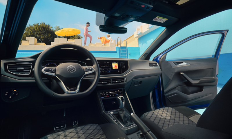 Vue à l'intérieur de la VW Polo avec le cockpit numérique pro en option, le volant avec des personnes à l'extérieur
