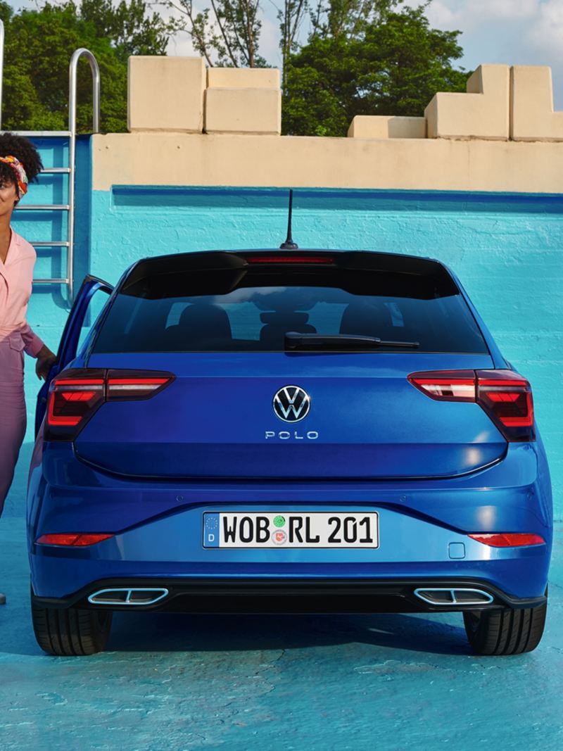 Blik på bagenden af en blå VW Polo, som holder parkeret i en tom pool. 