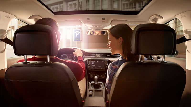 Ένας άντρας στη θέση του οδηγού και μια γυναίκα στη θέση του συνοδηγού στο εσωτερικό ενός Volkswagen - Φροντίδα Clean Plus