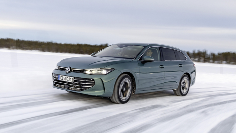 En grön VW Passat kör på vinterväglag, sedd snett framifrån
