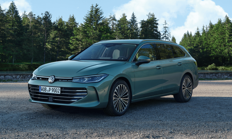 Zaparkowany w lesie zielony Volkswagen Passat