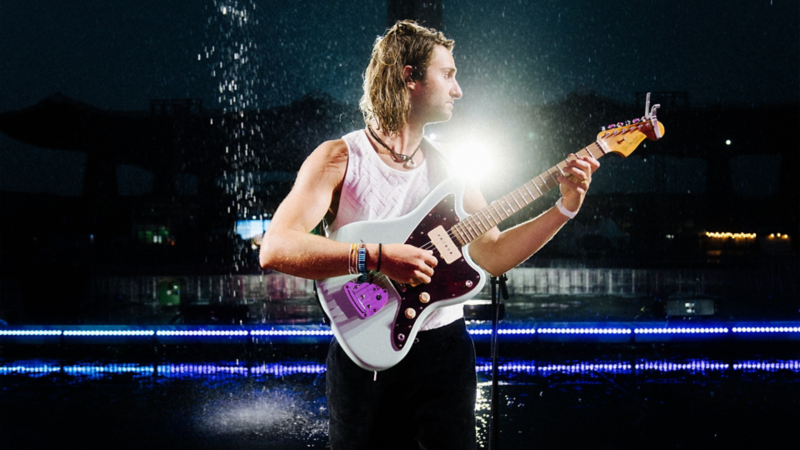 Pat Burgener mit seiner Gitarre in der Hand auf der Bühne