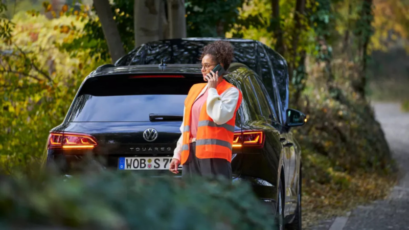 Vrouw met pech is aan het bellen, ze staat achter een Volkswagen Touareg