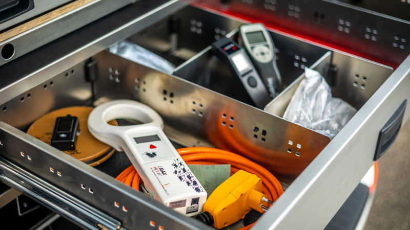 Un cassetto, riempito di materiale per inserti, nel vano bagagli del Multivan eHybrid