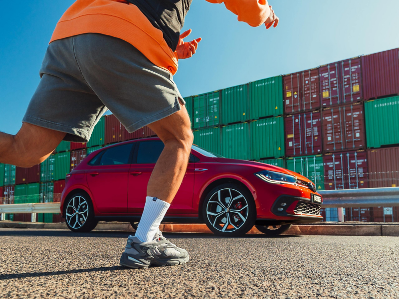 Model running with the Red Volkswagen Polo GTI in background