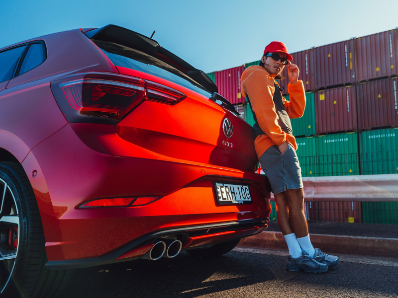 Man standing next to Volkswagen Polo GTI tail lights. 