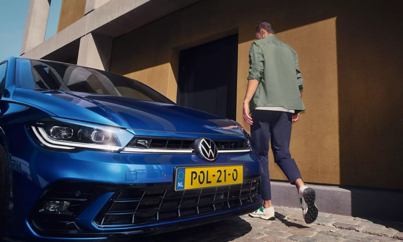 Man loopt voor een Polo R-Line langs 