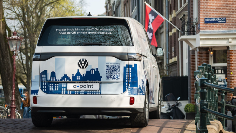 Achterkant ID. Buzz Cargo van a·point bij de Reguliersgracht. Tekst: Project in de binnenstad? Ga elektrisch. Scan de QR en test gratis deze bus.