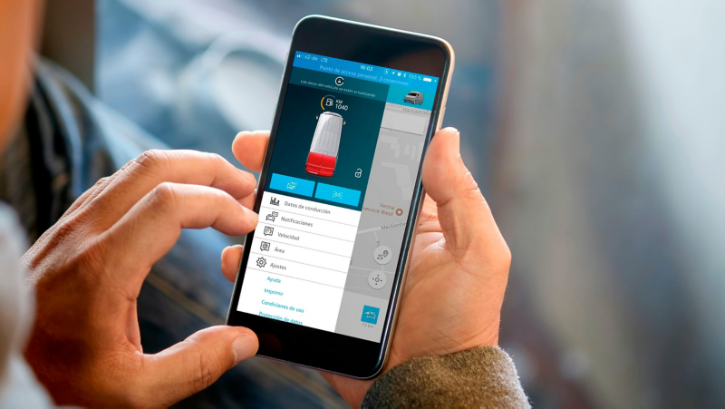Un hombre está comprobando el servicio de puertas y luces en la aplicación de VW Connect para asegurarse de que el vehículo está cerrado y no hay ninguna luz encendida.