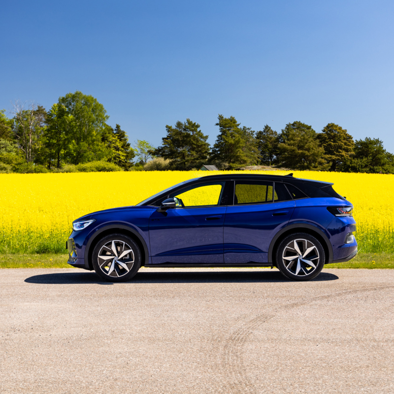 En blå ID.4 GTX parkerad framför ett gult rapsfält