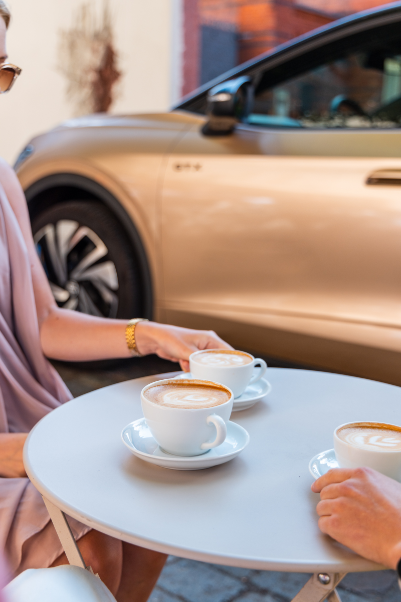 Tre koppar kaffe i framgrunden, Volkswagen ID.5 i bakgrunden